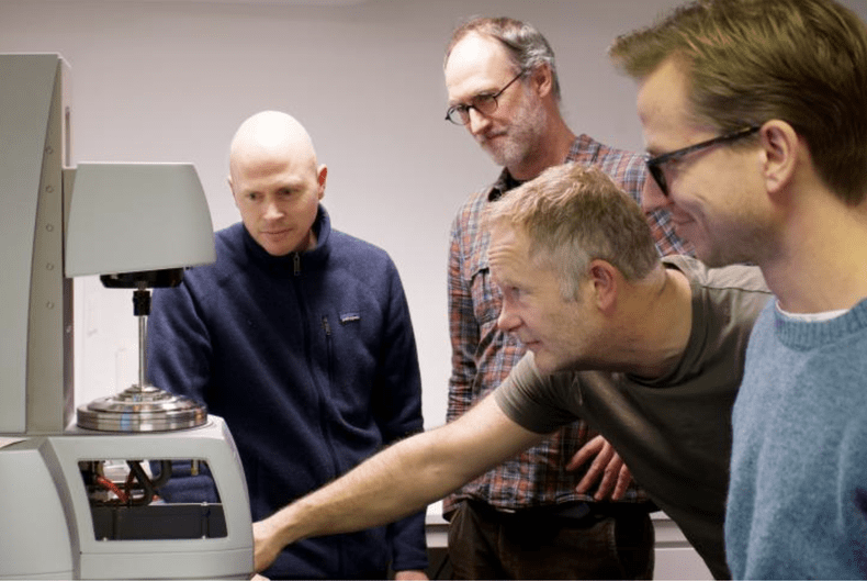 Andreas Carlson (tv), Atle Jensen, Eirik Strøm Lillebø and Torstein Sæter in front of a rheometer.